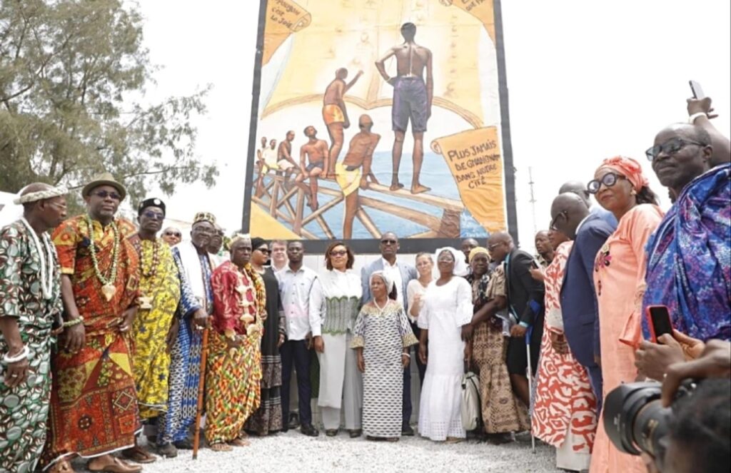 Habitants et chefs traditionnels devant une fresque mémorielle